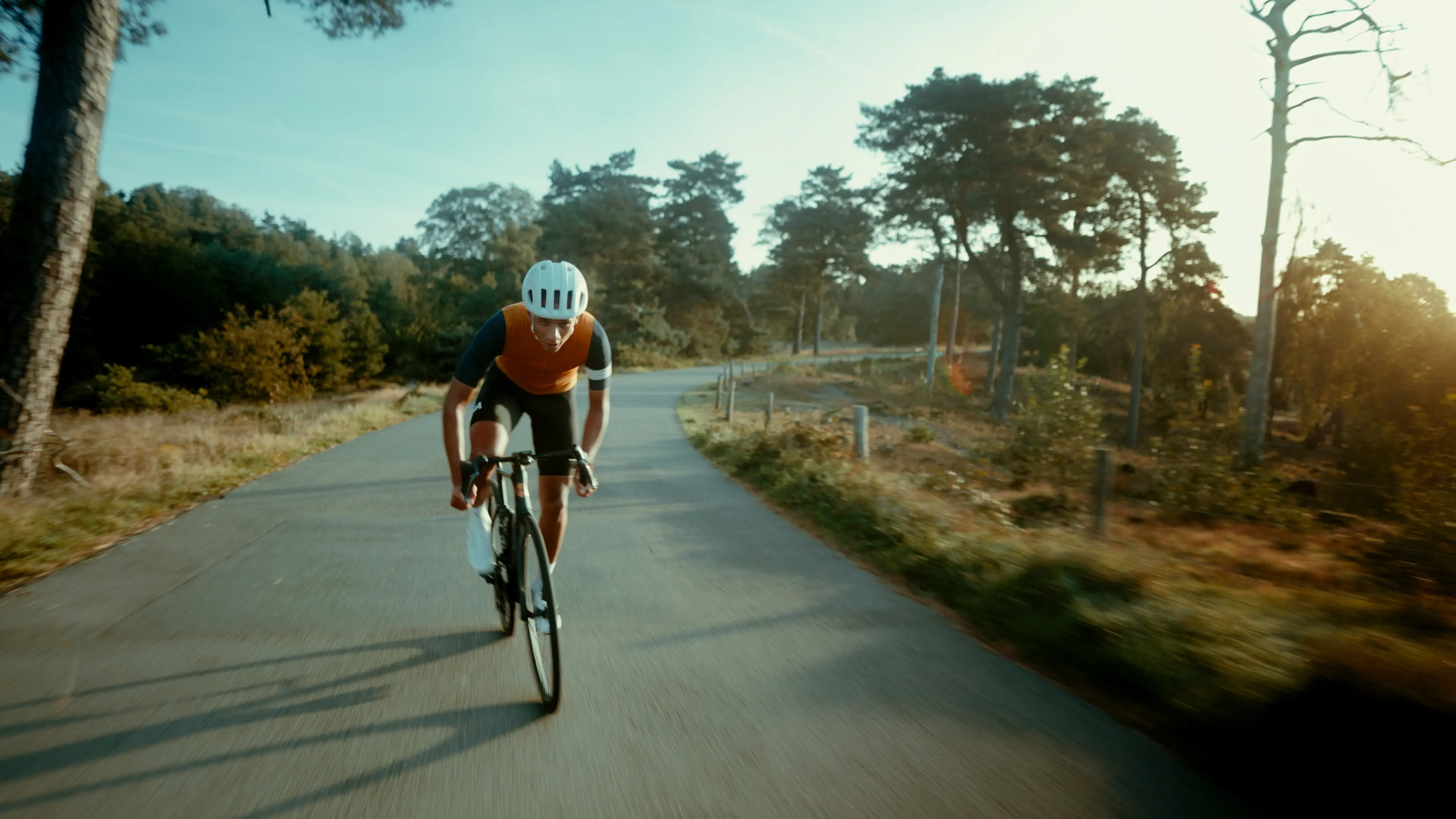 A cyclist sprinting on a bike riding on an asphalt road